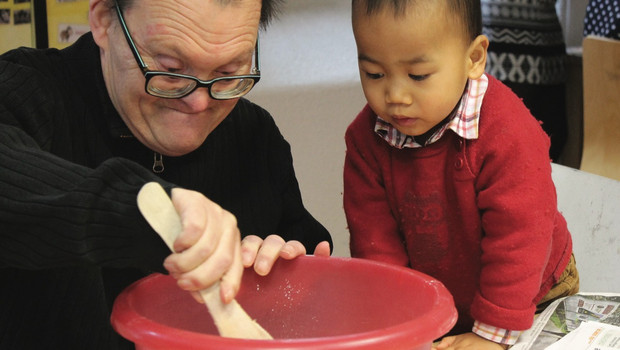 personne handicapée mentale avec un petit enfant asiatique font la cuisine